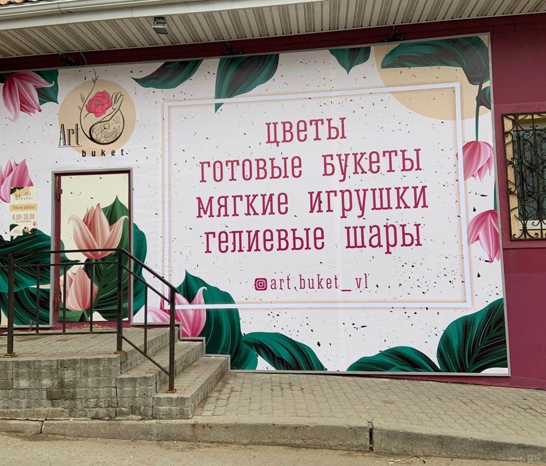 Вход в салон Art buket: белый фасад с цветами и вывеской «Цветы, готовые букеты, мягкие игрушки, гелиевые шары»